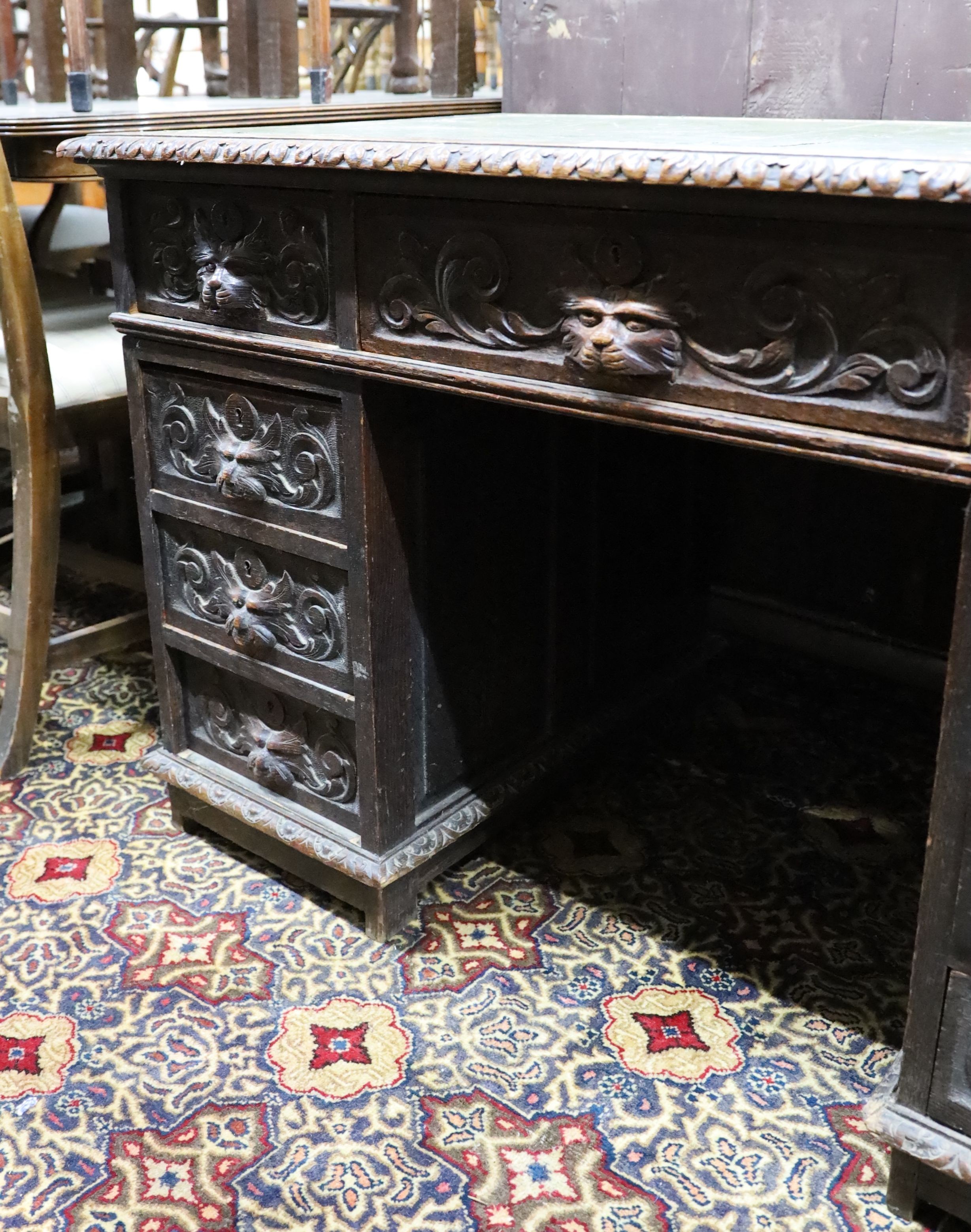 A late Victorian carved oak pedestal desk, length 121cm, depth 70cm, height 75cm